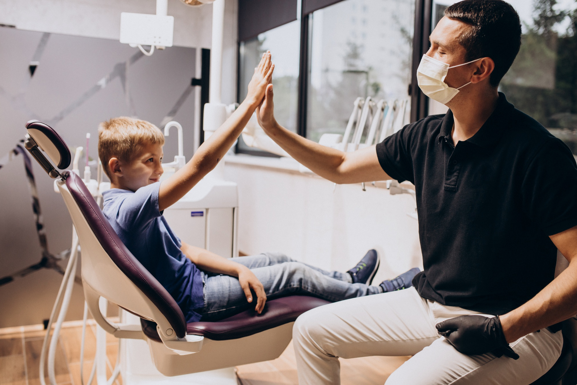 Child giving a dentist a high five after an appointment